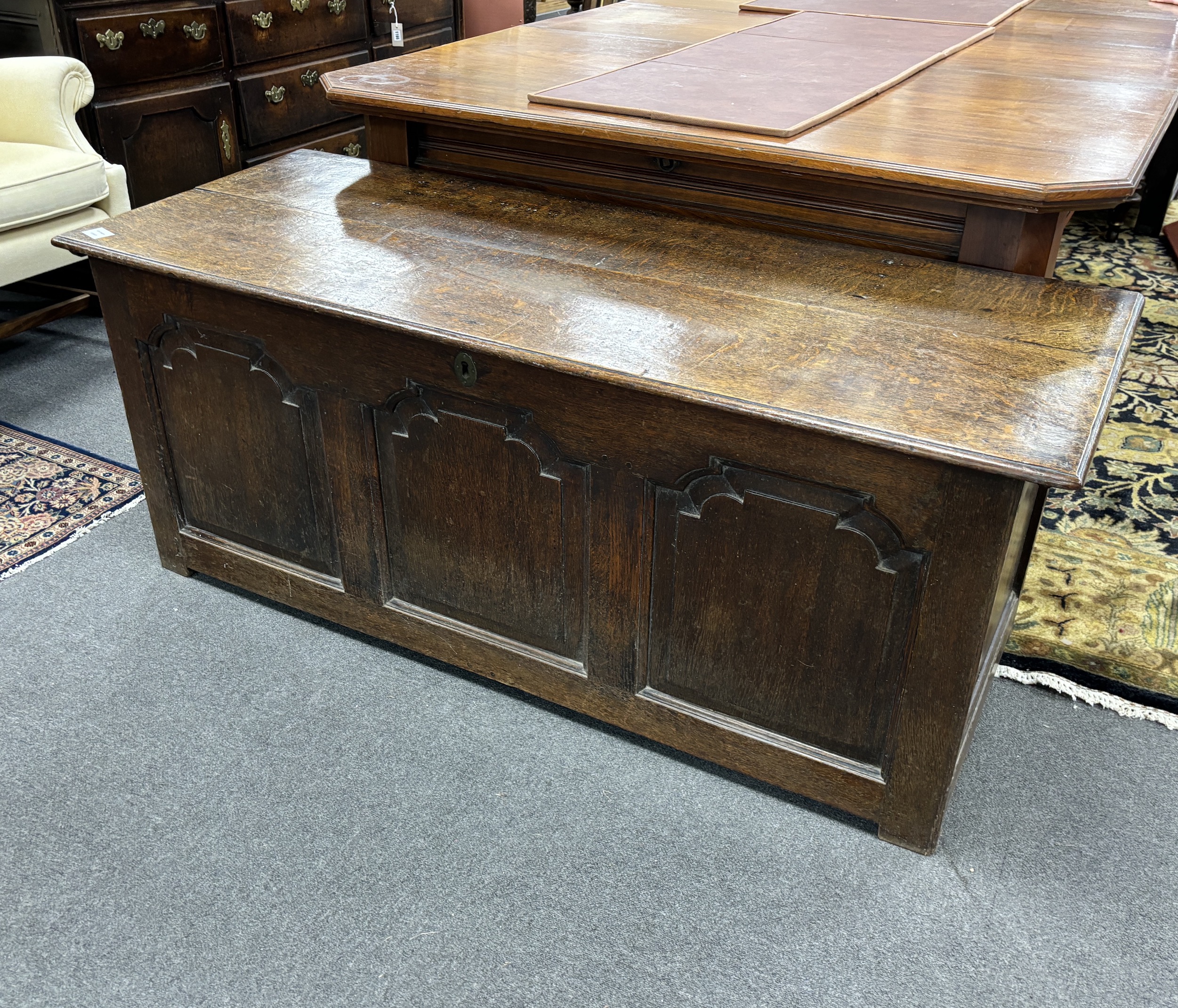 A mid 18th century oak coffer, with a triple arched fielded panelled front, width 146cm, depth 66cm, height 60cm